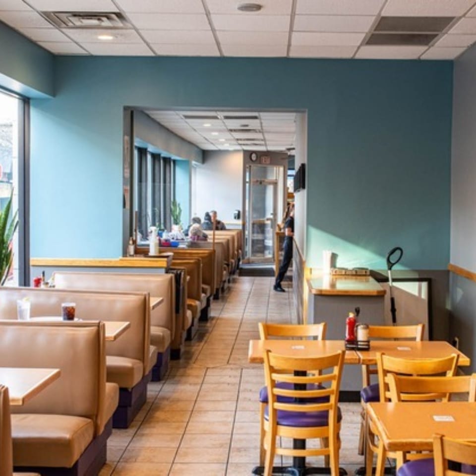 Interior of Stella's Diner with rows of booths, tables, and a few patrons.